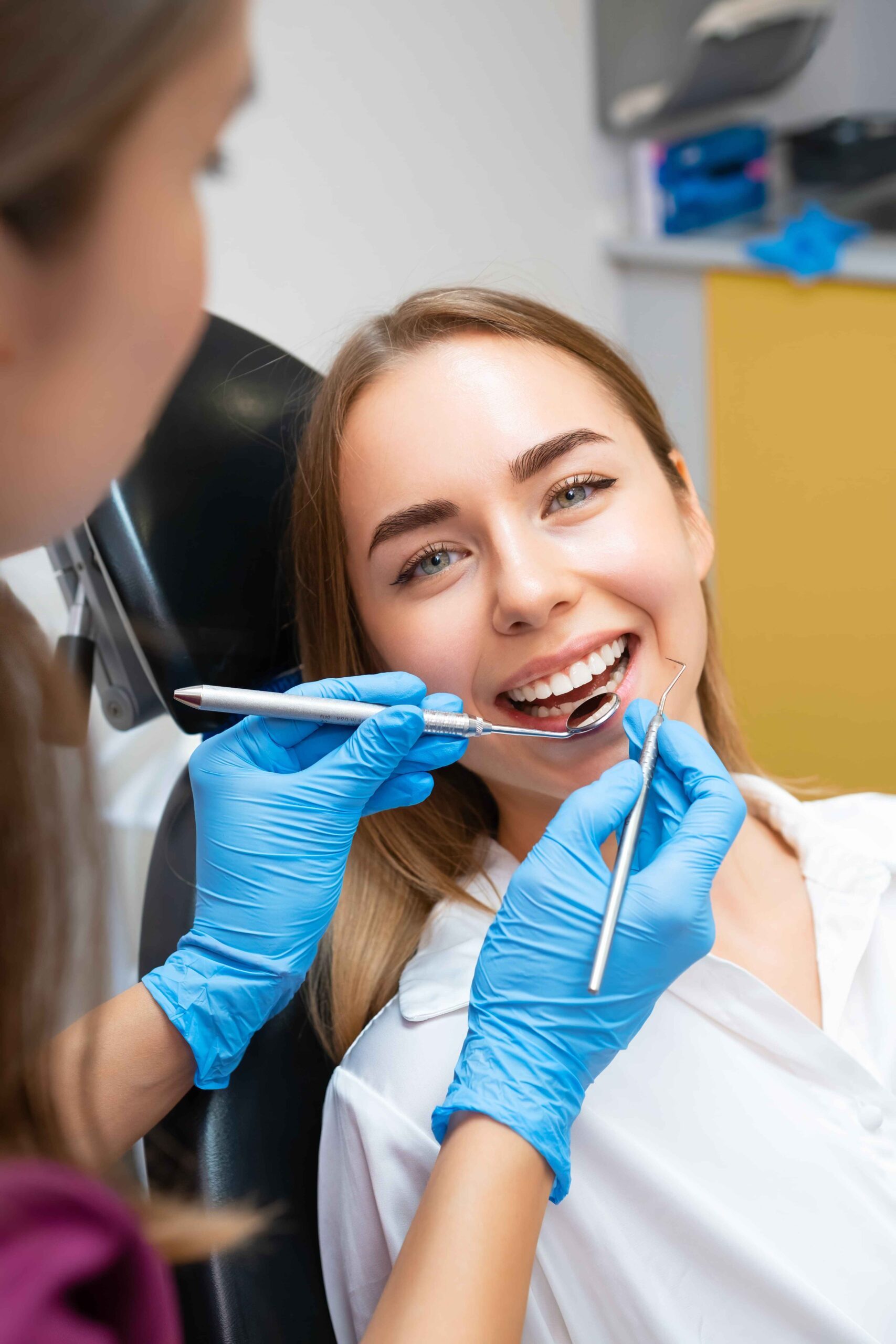 dentist-is-performing-dental-treatment-female-patient-with-flawless-smile-min (1)